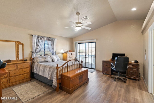 bedroom with hardwood / wood-style floors, vaulted ceiling, ceiling fan, access to exterior, and a textured ceiling