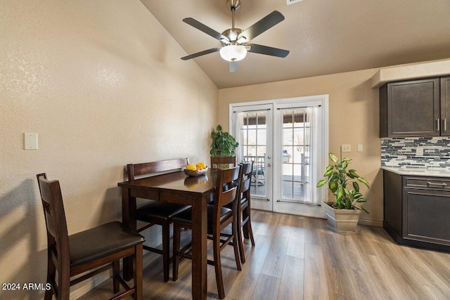 dining room featuring ceiling fan, lofted ceiling, french doors, and light hardwood / wood-style flooring