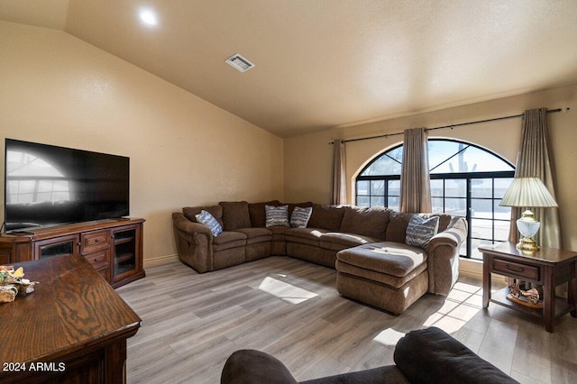 living room with light hardwood / wood-style floors and lofted ceiling