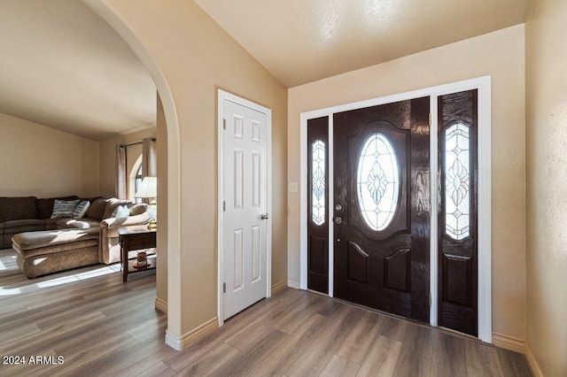 entryway featuring hardwood / wood-style floors and lofted ceiling