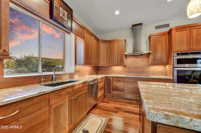 7304 E Bent Tree Dr, Scottsdale, AZ 85266 - kitchen with a sink, wall chimney exhaust hood, appliances with stainless steel finishes, light wood-style floors, and light stone countertops