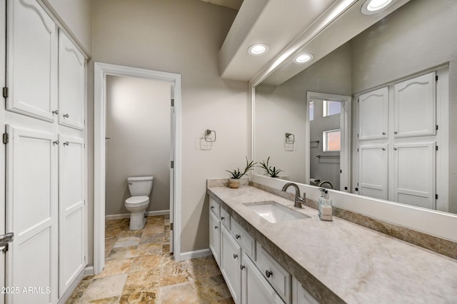 7304 E Bent Tree Dr, Scottsdale, AZ 85266 - bathroom with toilet, vanity, stone finish flooring, recessed lighting, and a closet