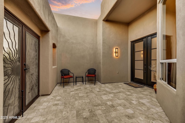 7304 E Bent Tree Dr, Scottsdale, AZ 85266 - exterior entry at dusk featuring french doors, a patio, and stucco siding