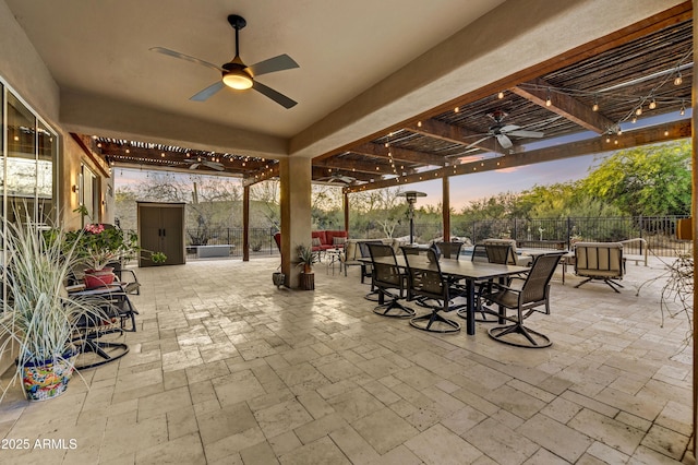 7304 E Bent Tree Dr, Scottsdale, AZ 85266 - patio terrace at dusk featuring a ceiling fan, outdoor dining area, a patio, and a pergola