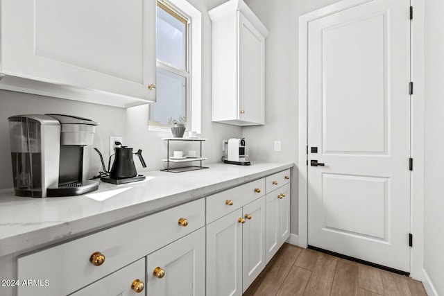 kitchen featuring white cabinetry and light stone counters