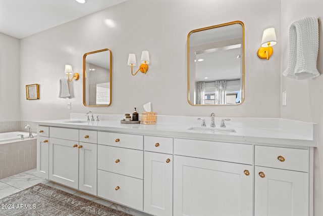 bathroom featuring tiled tub and vanity