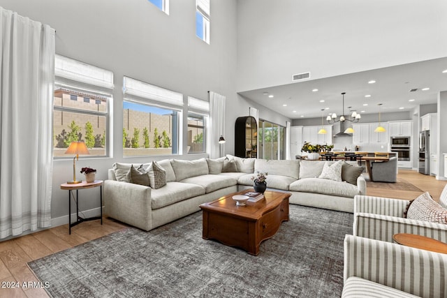 living room with a towering ceiling and wood-type flooring