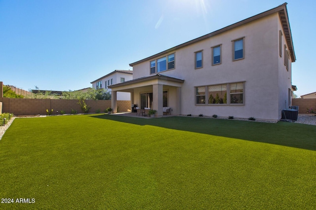 rear view of property with a yard, a patio, and cooling unit