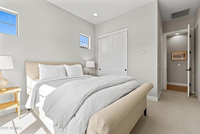 bedroom featuring light carpet and a closet