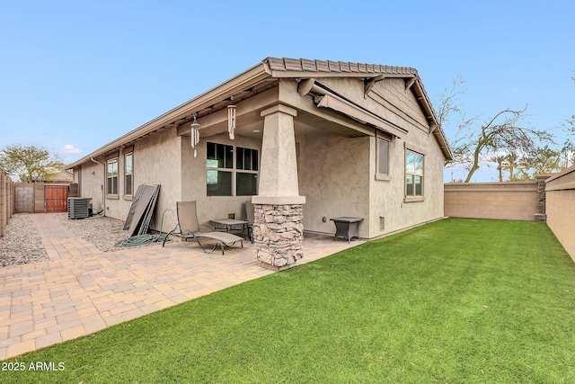 back of house with cooling unit, a yard, and a patio