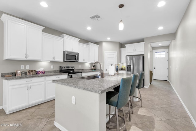 kitchen featuring an island with sink, stainless steel appliances, sink, and white cabinets