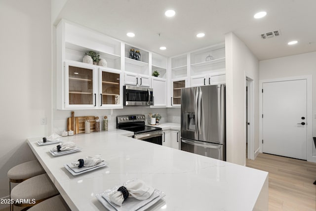 8965 E Maple Dr, Scottsdale, AZ 85255 - kitchen featuring appliances with stainless steel finishes, open shelves, a peninsula, white cabinets, and light wood-style flooring
