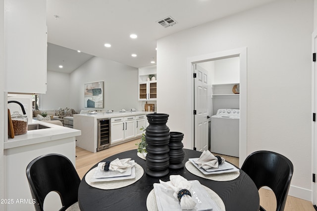 8965 E Maple Dr, Scottsdale, AZ 85255 - interior space with washer / clothes dryer, wine cooler, light wood-type flooring, recessed lighting, and vaulted ceiling