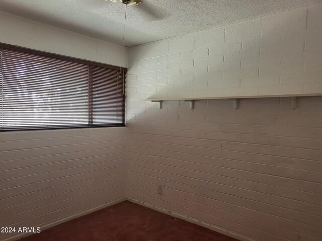 empty room with a textured ceiling and ceiling fan