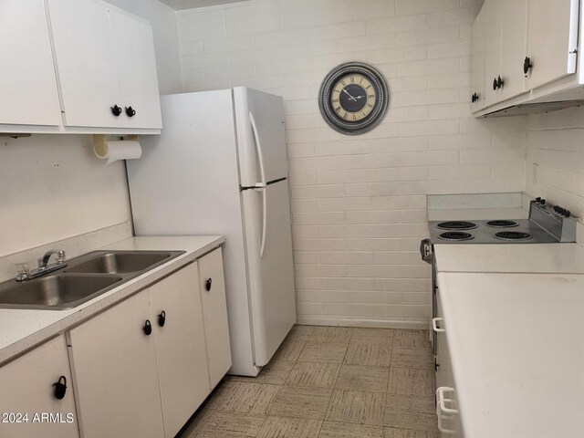 kitchen featuring sink, white electric stove, and white cabinetry