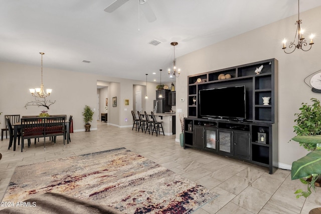 living room with ceiling fan with notable chandelier