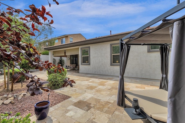 back of property featuring a gazebo and a patio