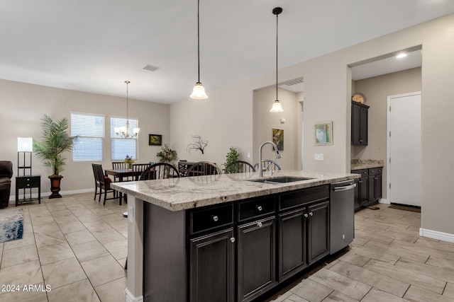 kitchen featuring sink, decorative light fixtures, stainless steel dishwasher, and a center island with sink