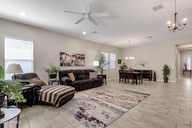 living room with ceiling fan with notable chandelier