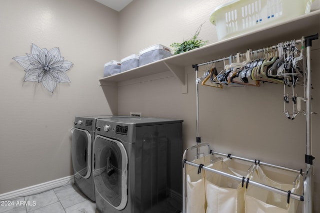 laundry room featuring independent washer and dryer and light tile patterned flooring