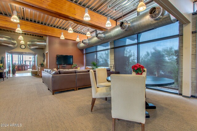 carpeted dining room featuring beamed ceiling