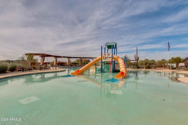 view of swimming pool with a playground