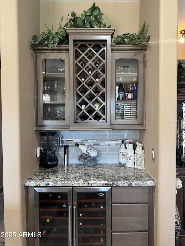 bar featuring backsplash, a bar, and wine cooler