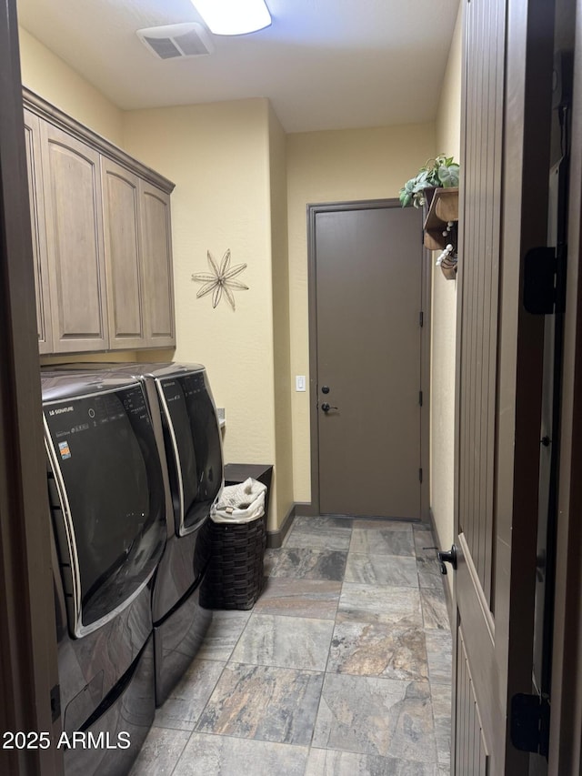 laundry area with cabinet space, independent washer and dryer, and visible vents