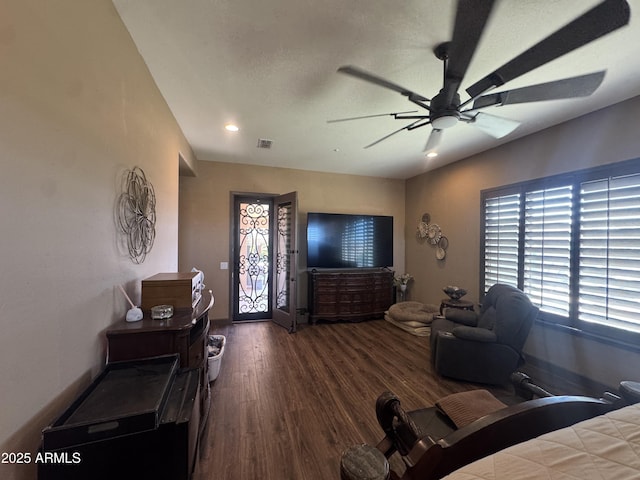 living area featuring plenty of natural light, a ceiling fan, wood finished floors, and visible vents
