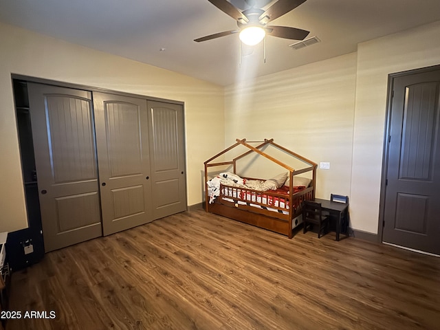 bedroom with visible vents, wood finished floors, lofted ceiling, and a closet