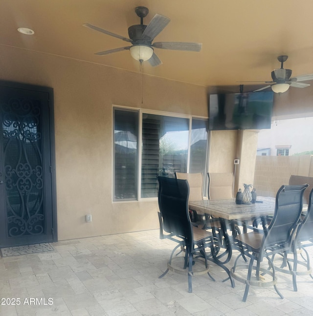 view of patio / terrace with ceiling fan, fence, and outdoor dining space