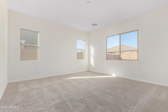 carpeted spare room featuring plenty of natural light