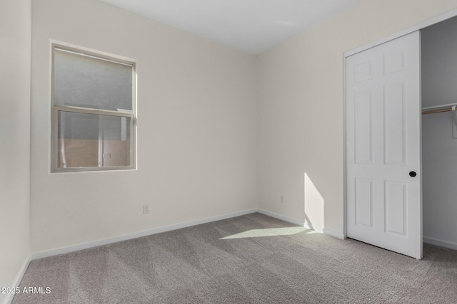 unfurnished bedroom featuring light colored carpet and a closet