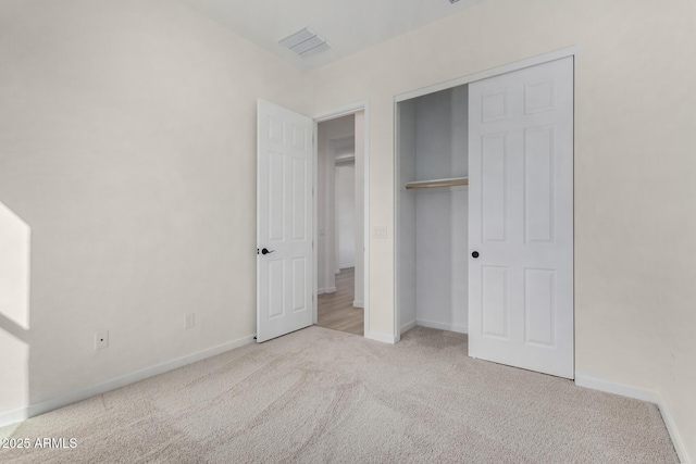 unfurnished bedroom featuring light colored carpet and a closet