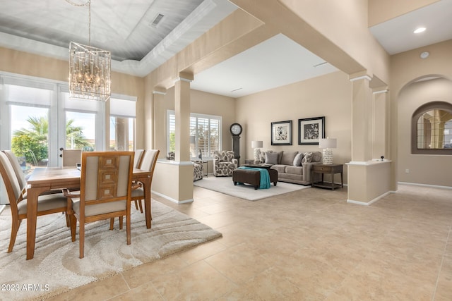 dining space with decorative columns and a chandelier