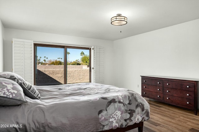 bedroom with wood-type flooring and access to outside