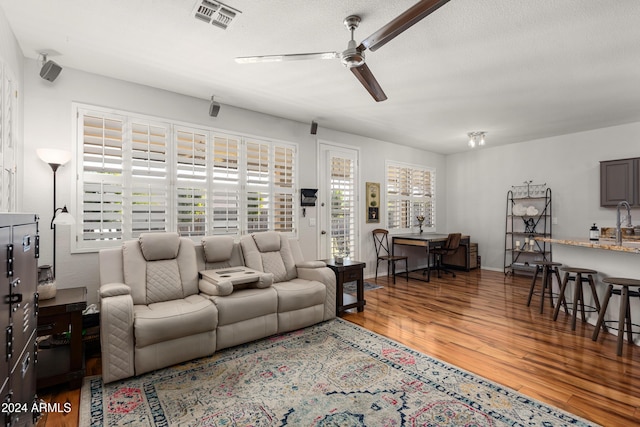 living room with hardwood / wood-style floors, a textured ceiling, and a wealth of natural light