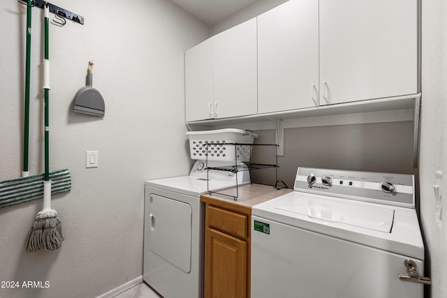 laundry room with separate washer and dryer and cabinets