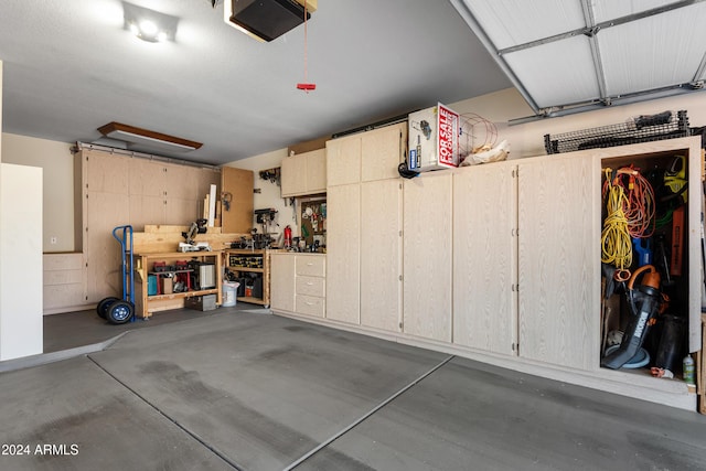 garage with a workshop area and a garage door opener