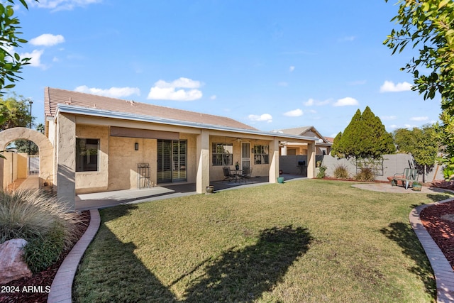 back of house featuring a patio and a lawn