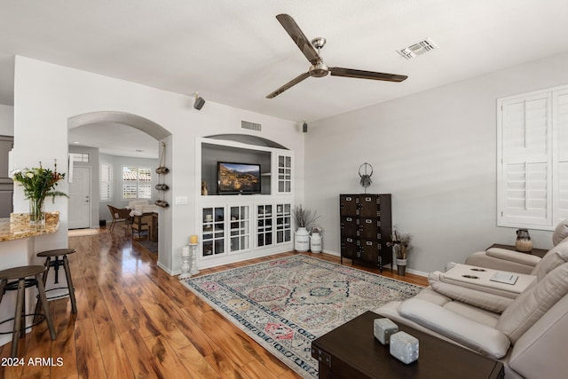 living room with ceiling fan and dark hardwood / wood-style flooring