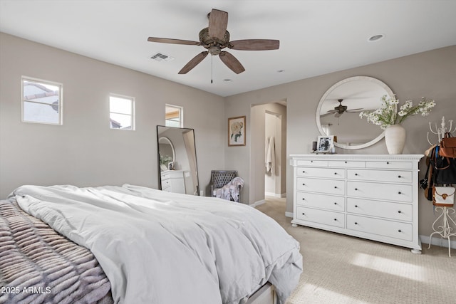 bedroom with light carpet, ceiling fan, visible vents, and baseboards