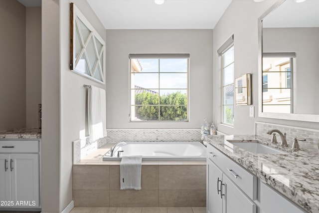 bathroom featuring a garden tub and vanity