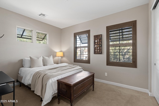 bedroom with light carpet, visible vents, and baseboards