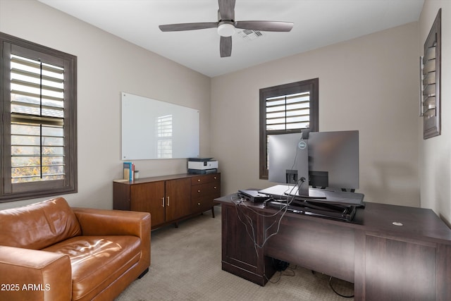 home office with ceiling fan, visible vents, and light colored carpet