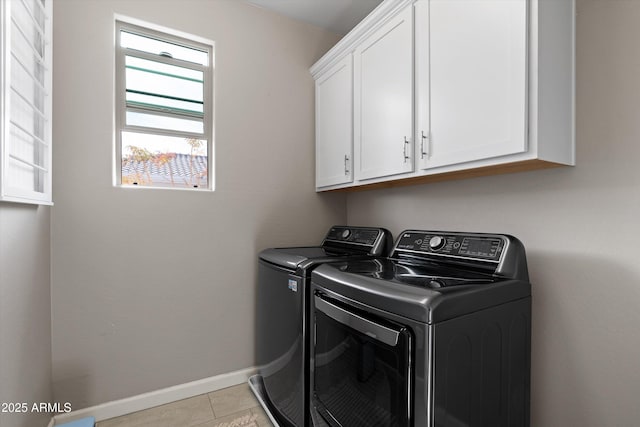 laundry area with cabinet space, washing machine and dryer, light tile patterned floors, and baseboards