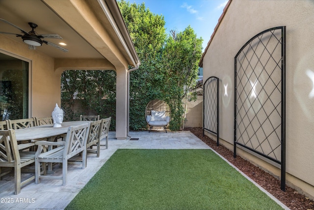 view of yard featuring fence, a ceiling fan, and a patio