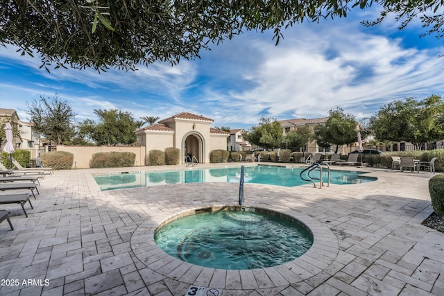 pool with a community hot tub, a patio, and fence