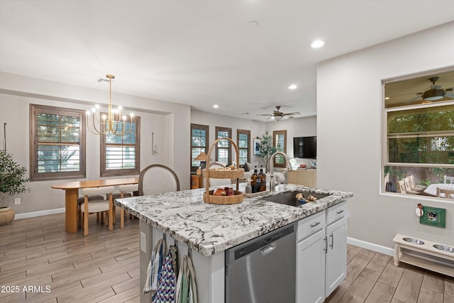 kitchen featuring a sink, white cabinets, stainless steel dishwasher, light stone countertops, and wood tiled floor