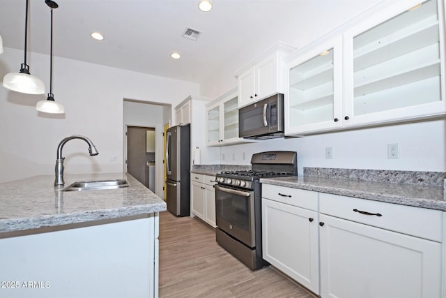 kitchen featuring a sink, visible vents, white cabinets, appliances with stainless steel finishes, and light wood-type flooring